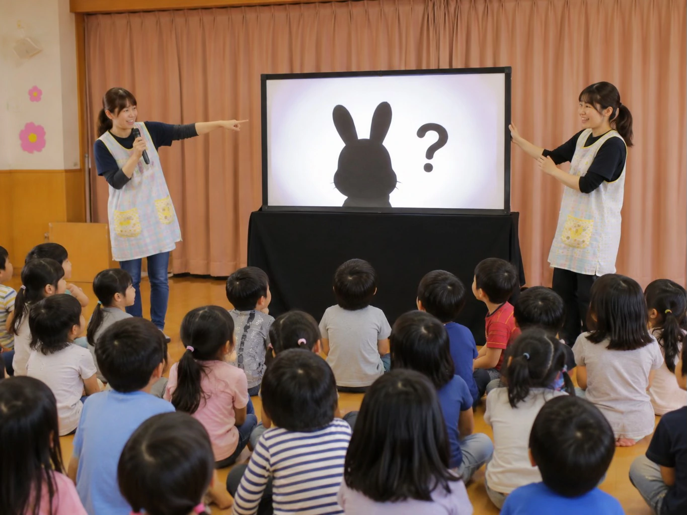 保育園のお楽しみ会でシルエットクイズを楽しむ園児たち