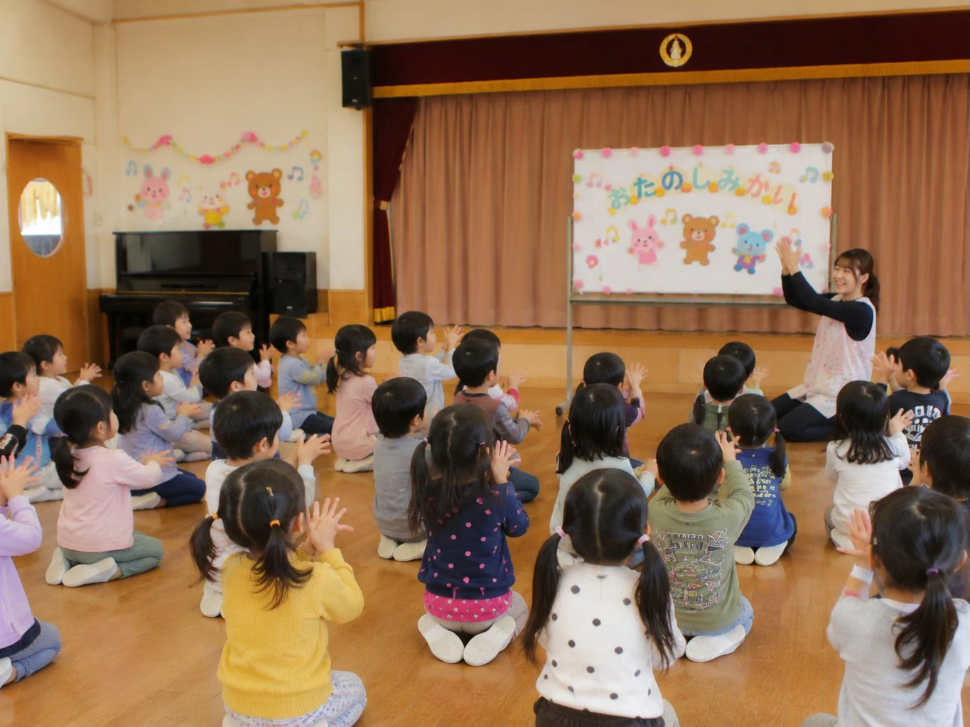 保育園のお楽しみ会で先生あてクイズを楽しむ園児たち