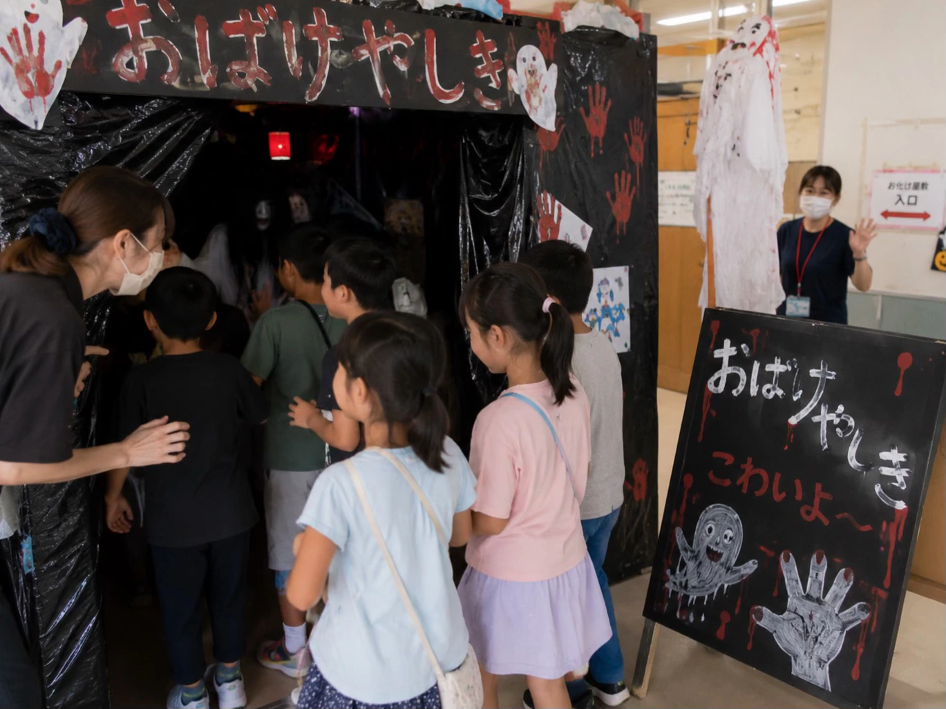 小学校のお祭りのお化け屋敷に並ぶ子どもたち