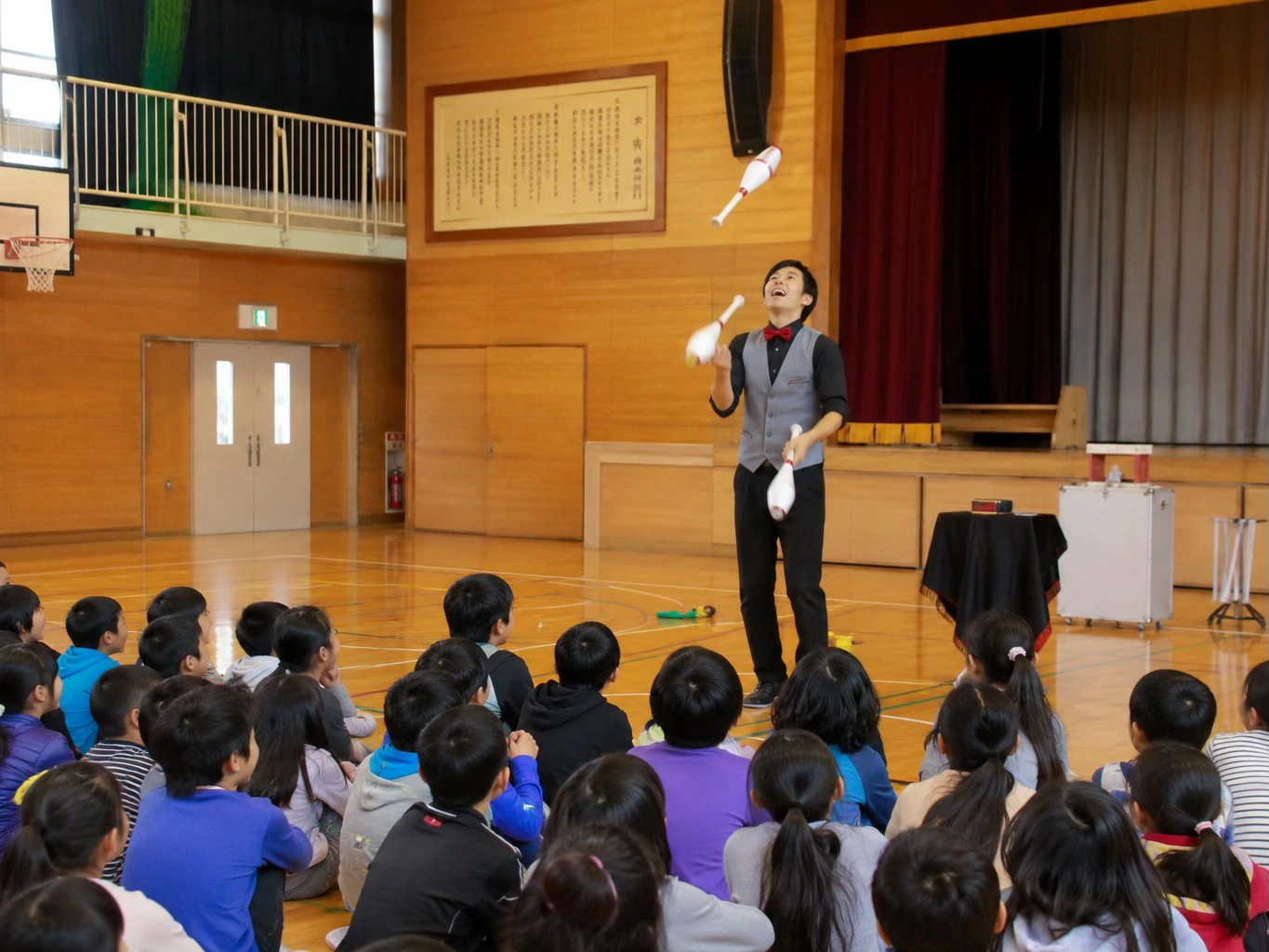 体育館でジャグリングショーを楽しむ子どもたち